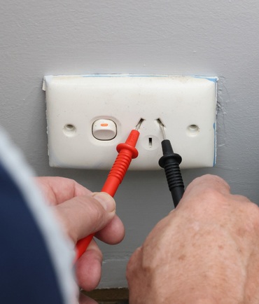 electrical safety inspection electrician checking plug voltage