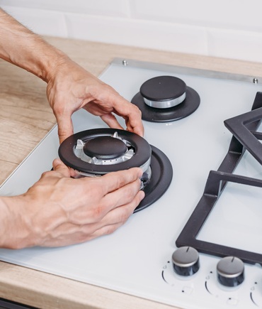 gas safety inspection man handling gas stove burner